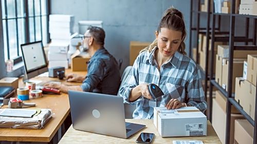 Two business partners working together at warehouse for online seller business.