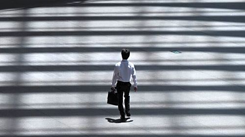 Entrepreneur's Mindset Man in suit walking into the light