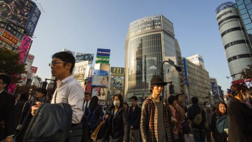 People walking in Japanese city at sunset