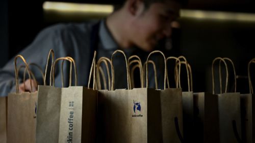 Employee behind Luckin Coffee paper bags