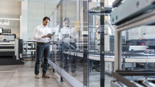 Man looking at tablet in a modern automated workspace