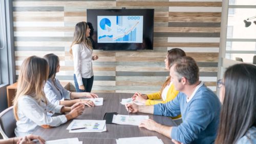 A woman presents to the company board about cloud costs