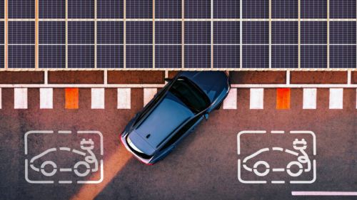 Aerial view of an EV pulling into a charging station