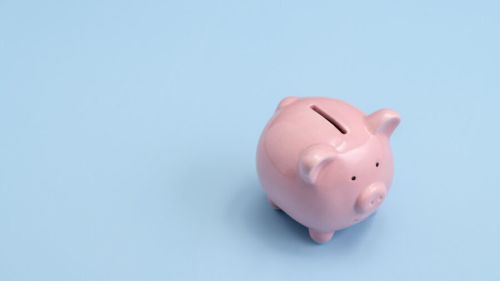 Pink Piggy Bank On Blue Background.