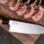 KAI Seki Magoroku Redwood Santoku Knife, lifestyle with rack of lamb