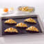 NoStik Reusable Baking Liner, on tray with croissants