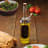 KitchenCraft World of Flavours Dual Oil and Vinegar Pourer - Tall on the table with a green salad dish