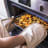 MasterClass Deluxe Professional Double Oven Glove, Cream taking a hot pan out of the oven