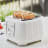 DeLonghi Ballerina 4-Slice Toaster, 1800W - Opaline White on the table with toasted bread