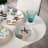 Olivia Cuzins Side Plates, Set of 4 on the table with a glass