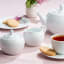 Noritake Arctic White Creamer Jug with a teapot, cup of tea and side plate with cookies