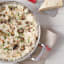 Le Creuset 3 Ply Non-Stick Stainless Steel Chefs Pan with food on the table