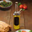 KitchenCraft World of Flavours Dual Oil and Vinegar Pourer - Tall on the table with a green salad dish