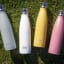 Built Double Walled Stainless Steel Water Bottle, 480ml - Powder Pink on the grass with other colours