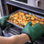 MasterClass Silicone & Cotton Double-Sided Oven Glove, Green removing a hot pan of potatoes from the oven