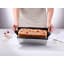 NoStik Reusable Cake Tin Liner, Rectangular with cake lifting out of loaf tin