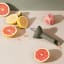 Eva Solo Green Tool Citrus Press on the kitchen counter with citrus fruits