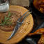 Kuchenprofi Poultry Scissors on a wooden board next to cooked chicken