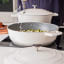 MasterClass Cast Aluminium 4L Shallow Casserole Dish, 28cm - Cream on the stove with lid on the side