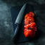 Wüsthof Performer Cook_s Knife, 20cm on a board next to a tomato