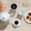 Noritake Arctic White Large Porcelain Mugs with coffee next to a cup of tea, a teapot and plate of mini pecan pies 