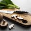 Sagenwolf Performance Kitchen Knife, 12cm on a wooden board with Sliced mushrooms and bok choy 