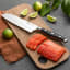 Sagenwolf Performance Santoku Knife, 18cm on a wooden Board with sliced salmon 