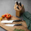 Sagenwolf Performance Santoku Knife, 18cm at a table setting with a chopping board and knife block 