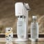 Sodastream Art Sparkling Water Maker - White with carbonating bottles and a glass of sparkling water