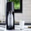 Sodastream Terra Sparkling Water Maker - Black with a carbonating bottle and a glass of sparkling water