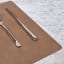 Lind DNA Nupo Leather Square Leather Table Mat - Brown on the table with cutlery