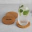 Oh Nice Oak Wood Coasters, Pack of 4 - Oak on the table with a glass of sparkling water