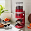 KitchenAid Burr Grinder - Empire Red with two cups of coffee on the kitchen counter