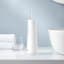 Usmile Advance Care Ultrasonic Oral Irrigator next to the basin