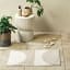 Linen House Cue Bathmat - Stone on the bathroom floor next to small table and shoes