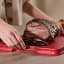 Joseph Joseph Cut and Carve Plus Chopping Board, Extra Large - Red on the kitchen counter with sliced steak