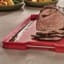 Joseph Joseph Cut and Carve Plus Chopping Board, Extra Large - Red on the kitchen counter with sliced steak