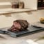 Joseph Joseph Cut and Carve Plus Chopping Board, Extra Large - Sky with sliced steak on the table