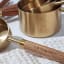 Trendz Of Today Gold & Wood Measuring Cup and Spoon Set detail on the table