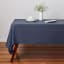 Maxwell & Williams Cotton Classics Rectangular Tablecloth, 3m - Denim on the table with a dinner set and a flower pot