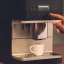 Miele Silence Freestanding Coffee Machine - Obsidian Black with a cup of coffee