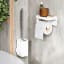 Umbra Flex Adhesive Toilet Brush - White in use against wall next to toilet