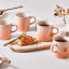 Le Creuset Peche Stoneware Mug, 350ml with other mugs on the table