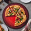 Le Creuset Pizza Stone, 38cm - Cerise with pizza on the table