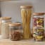 KitchenCraft Idilica  Glass Storage Jar with Beechwood Lid - Large on the table