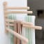 KitchenCraft Idilica Beechwood 6-Rail Wall Rack with cloths on the wall