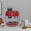 Smeg Stainless Steel Milk Jug, 450ml on the counter with the coffee machine