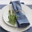 Linen House Revana Chambray Napkins, Set of 4 - Navy on a plate