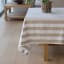 Linen House Revana Stone Stripe Tablecloth with a plant on the table