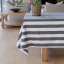 Linen House Revana Black Stripe Tablecloth with a plant on the table